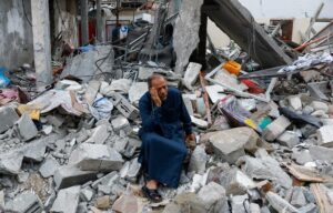 Israel-Hamas War: A Palestinian sitting o the rubble of a destroyed House through the Israel airstrikes